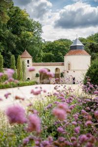 Reugny的住宿－Relais & Château Louise de La Vallière，一座花园,在一座建筑前方种有粉红色花卉