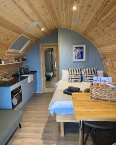 ein Schlafzimmer mit einem Bett und einem Tisch in einem Zimmer in der Unterkunft Craigend Farm Holiday Pods - The Woolly Sheep in Dumfries