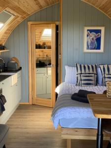 a bedroom with a bed and a kitchen at Craigend Farm Holiday Pods - The Woolly Sheep in Dumfries
