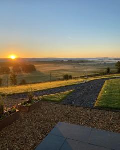 a view of the sunset from a garden at Craigend Farm Holiday Pods - The Woolly Sheep in Dumfries