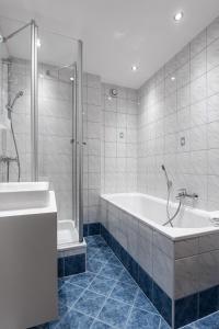 a white bathroom with a tub and a shower at Gschwendtners Apartment in Werfenweng