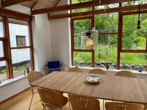 uma sala de jantar com uma mesa de madeira e cadeiras em Dejligt hus på landet em Give