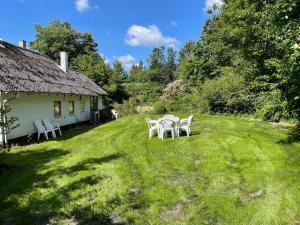 podwórko z białymi krzesłami i dom w obiekcie Dejligt hus på landet w mieście Give