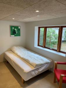 - un lit dans une chambre avec 2 fenêtres dans l'établissement Dejligt hus på landet, à Give