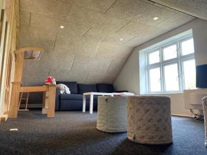a living room with a couch and a table at Dejligt hus på landet in Give