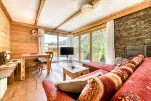 a living room with a red couch and a table at Uralp Royal by A-Appartments in Brand