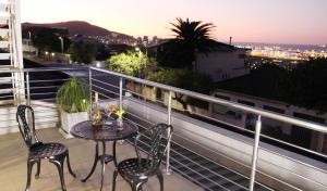 una mesa y sillas en un balcón con vistas en Harbour View Guest Suite, en Ciudad del Cabo