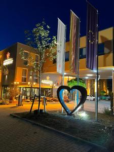 a heart sculpture in front of a building at night at Hotel Winterrot in Karlsruhe