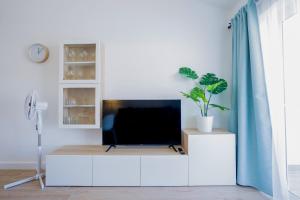 salon z telewizorem na białej szafce w obiekcie Bright & Stylish Apartment in Chipeque, Los Cristianos w Aronie