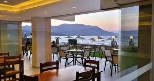 a restaurant with tables and chairs and a view of the ocean at Sunny Bay Hotel in Kissamos