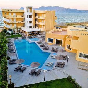 an aerial view of a hotel with a pool and chairs at Sunny Bay Hotel in Kissamos