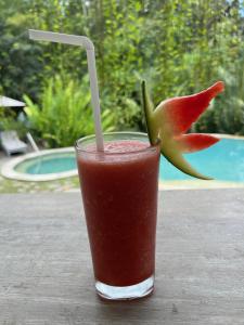 a drink sitting on a wooden table with aasy at Balian Bliss Retreat Bungalow & Villas in Balian