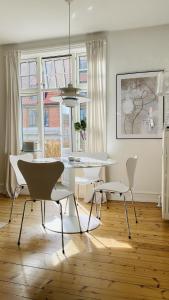 a white dining room with a table and chairs at ApartmentInCopenhagen Apartment 1511 in Copenhagen