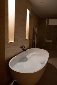 a bath tub in a bathroom with two lights at The Breakers in Brancaster