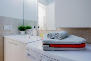 biała łazienka z zestawem ręczników na ladzie w obiekcie Bright & Stylish Apartment in Chipeque, Los Cristianos w Aronie