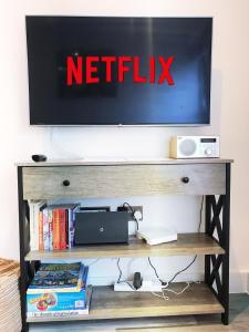 anetflix sign on top of a television on a shelf at Gild House 2-bedroom apartment close to Town Centre in Bournemouth