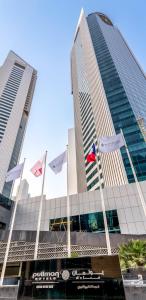 Pullman Doha West Bay في الدوحة: مجموعة من الأعلام تتطاير أمام المبنى