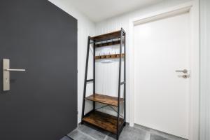 a closet with a wooden shelf next to a door at Apartmány Horská, Vrchlabí in Vrchlabí