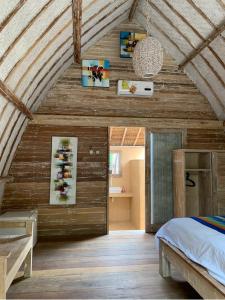 a bedroom with wooden walls and a bed in a room at Star Bar and Bungalows in Gili Air