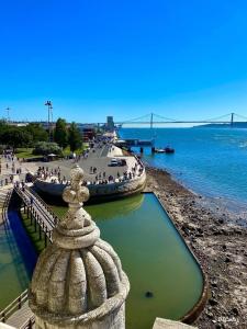 a group of people walking on the beach near the water at Belém- Charming Apartments in Lisbon