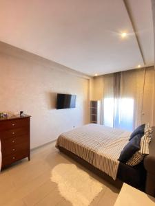 a bedroom with a bed and a tv on the wall at Residence Boule d'OR- EMPLACEMENT - NETFLIX - FREE PARKING in Casablanca