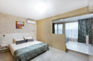 une chambre d'hôtel avec un lit et une fenêtre dans l'établissement Hotel Capri, à Plovdiv