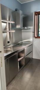 La cuisine est équipée de comptoirs en acier inoxydable et d'un évier. dans l'établissement B&B af, à Massafra