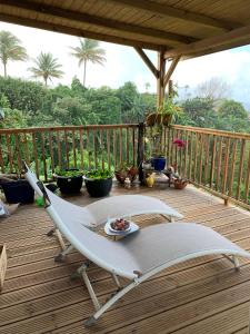 een terras met een tafel en stoelen op een veranda bij Maison vue sur la mer Jardin d Orient in Saint-Claude