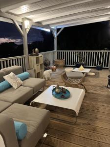 - un salon avec un canapé et des tables sur une terrasse dans l'établissement Maison vue sur la mer Jardin d Orient, à Saint-Claude