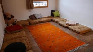 sala de estar con sofá y alfombra naranja en Chaleureuse maison avec Jacuzzi en Le Mas-dʼAzil