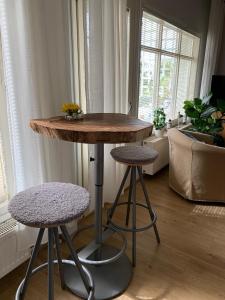 a table and two stools in a living room at Lillmåsen Naantali - atmospheric and very comfy studio in Naantali