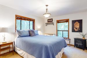a bedroom with a blue bed and two windows at Sunrise Mountain Retreat in Cazadero