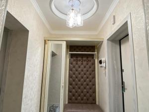 a hallway with a door and a chandelier at APARTMENT “NOVZA” in Tashkent