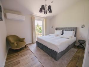 a bedroom with a bed and a chair and a window at Quinta dos Românticos - Charm House & Wine SPA in Peso da Régua