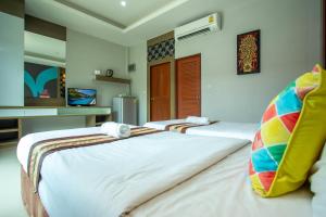 two beds in a room with white walls at Areeka Resort Phuket in Thalang