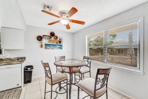 eine Küche mit einem Tisch und Stühlen sowie einem Deckenventilator in der Unterkunft Blissful Beach Retreat B in Englewood