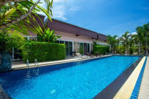 a swimming pool in front of a house at Areeka Resort Phuket in Thalang