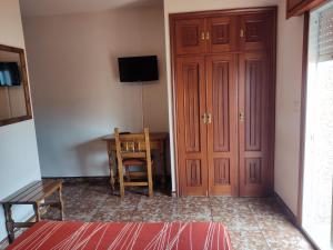 Pokój z biurkiem, drzwiami i krzesłem w obiekcie Hostal Las Vegas w mieście Cangas de Morrazo +17 zdjęć