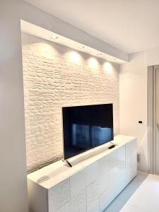 uma sala de estar com uma grande televisão de ecrã plano na parede em La Suite sul Mare 1 em Montesilvano