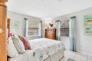 ein Schlafzimmer mit einem Bett und zwei Fenstern in der Unterkunft Blissful Beach Retreat B in Englewood