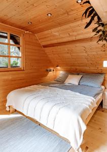 ein Schlafzimmer mit einem Bett in einer Holzhütte in der Unterkunft Kispatak Vendégház in Zebegény