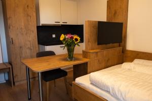 een slaapkamer met een tafel met een vaas met bloemen erop bij HeindlHof in Ingolstadt