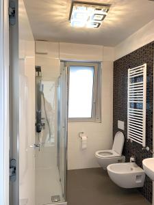 uma casa de banho com um chuveiro, um WC e um lavatório. em La Suite sul Mare 1 em Montesilvano