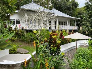 a house with a garden and an umbrella at Balian Bliss Retreat Bungalow & Villas in Balian