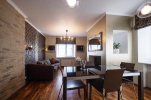 uma sala de jantar e sala de estar com uma parede de tijolos em Revalia Airport-Bus Station One-Bedroom Apartment em Talin