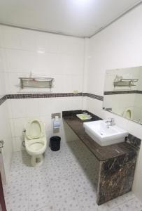 a bathroom with a toilet and a sink at Sunshine Garden in Susupe