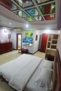 a bedroom with a large white bed and a ceiling at Sunshine Garden in Susupe