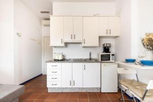 uma cozinha com armários brancos e um micro-ondas em GINVA - Apartahotel El Rocio-Doñana em El Rocío