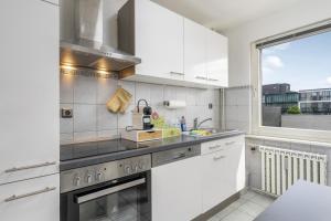 a kitchen with white appliances and a large window at FREE LIVING - VW näher geht nicht, Parkplatz, Küche, Wlan in Wolfsburg