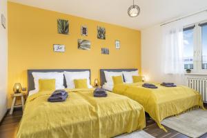 2 łóżka w pokoju z żółtymi ścianami w obiekcie FREE LIVING - VW näher geht nicht, Parkplatz, Küche, Wlan w mieście Wolfsburg